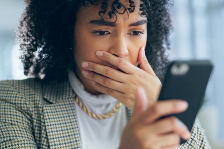 woman looking at her phone in shock