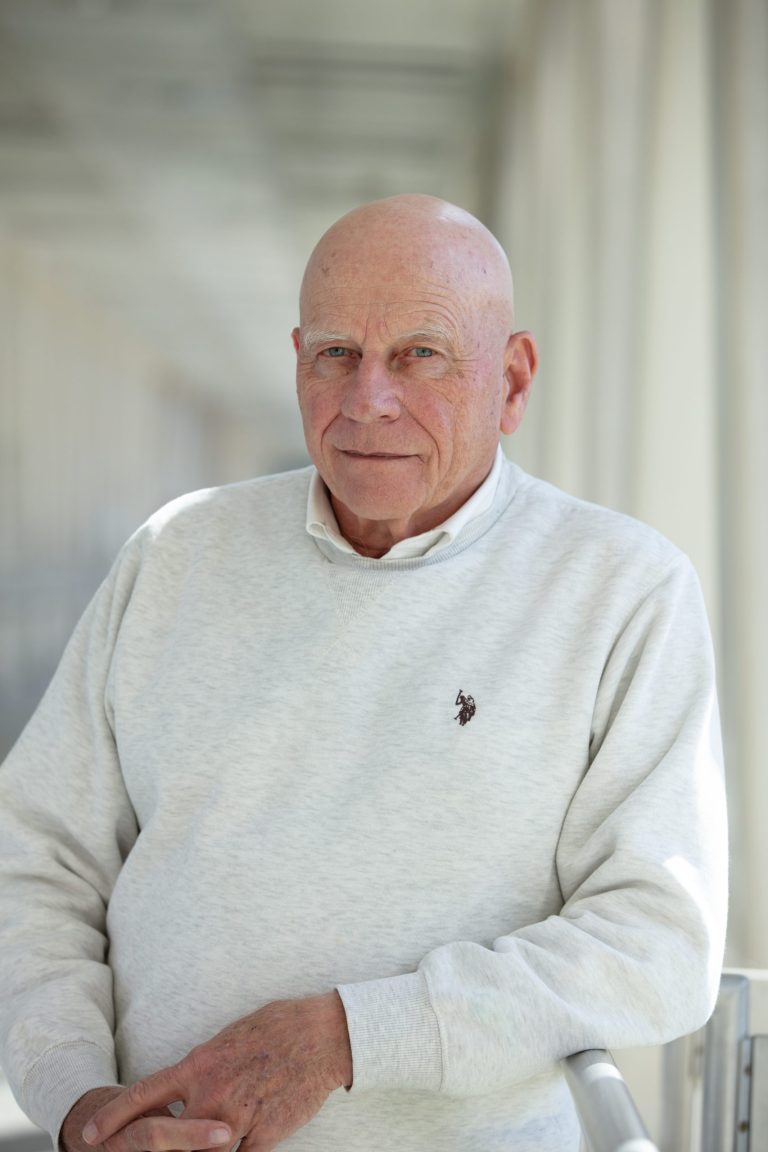 Professional headshot of VPLC employee Daniel Sullivan, who is wearing a white sweater with a white collared shirt underneath.