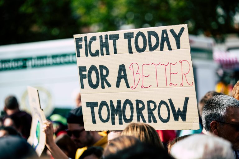 protester holding sign that reads fight for a better tomorrow