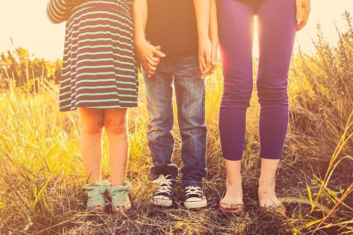 siblings shown from the waist down holding hands