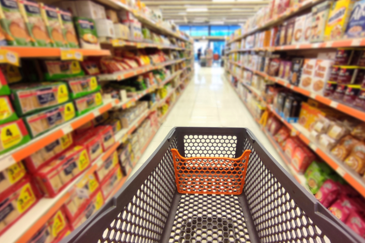 Empty grocery cart going down grocery aisle