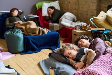 children and adults on cots
