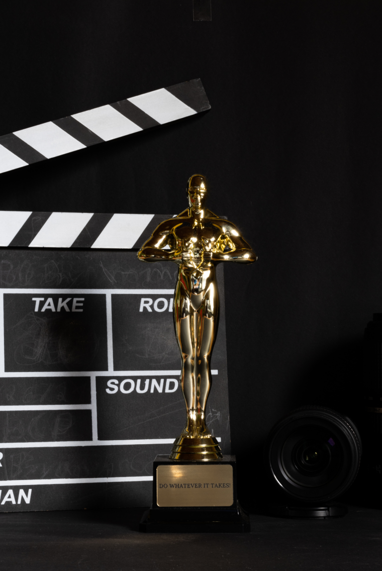 clapperboard with trophy in front of it