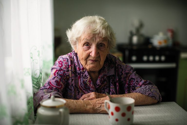 Elderly woman sitting at the table.