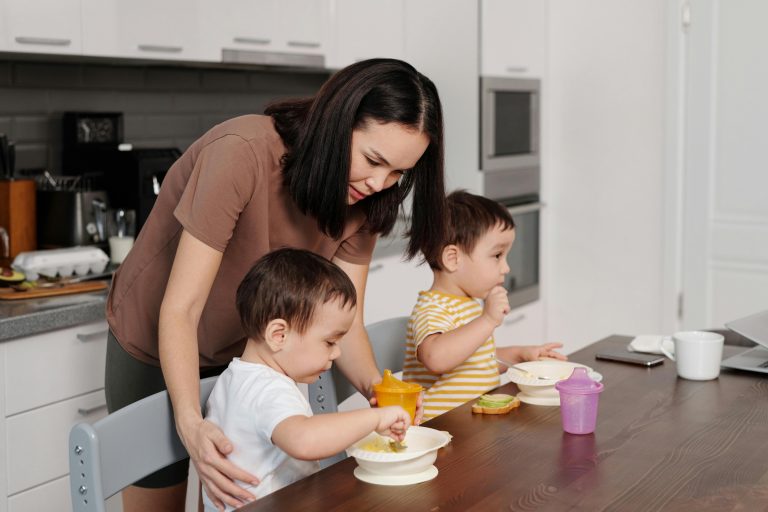 woman attending to her two boys eating in the kitchen