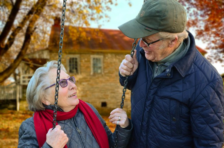 couple outside in the Fall, woman on swing