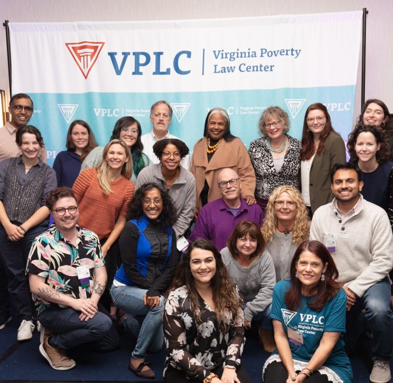 A group of staff people posing together in front of a backdrop for Virginia Poverty Law Center (VPLC).