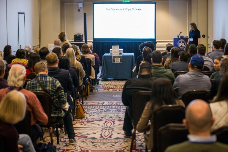 woman presenting to crowd at conference