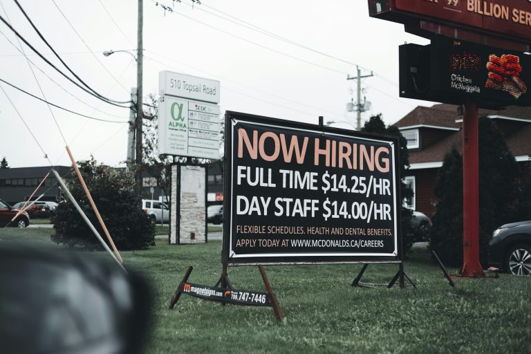 outside sign reading now hiring