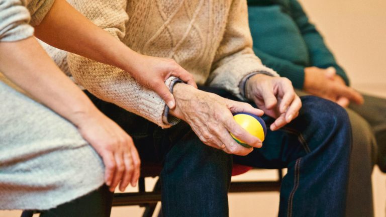 woman holding man's wrist holding ball
