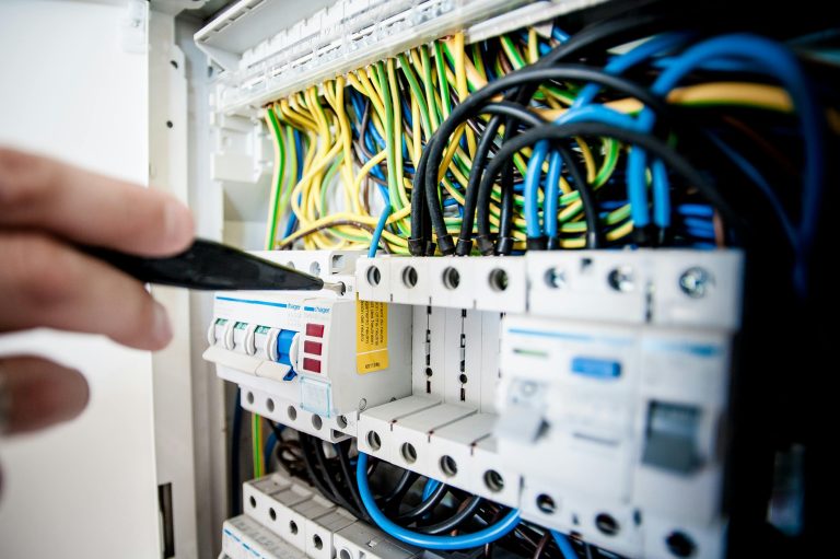 complex electrical machine with colored wires being adjusted with a tiny screwdriver