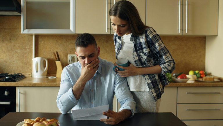 A couple looking with concern at a bill