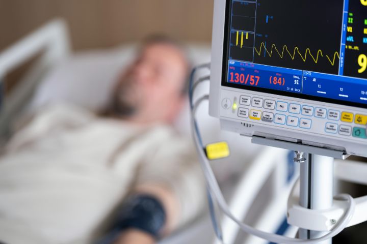 man lying in hospital bed with medical equipment