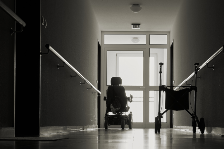 Empty chair and walker in nursing home hallway
