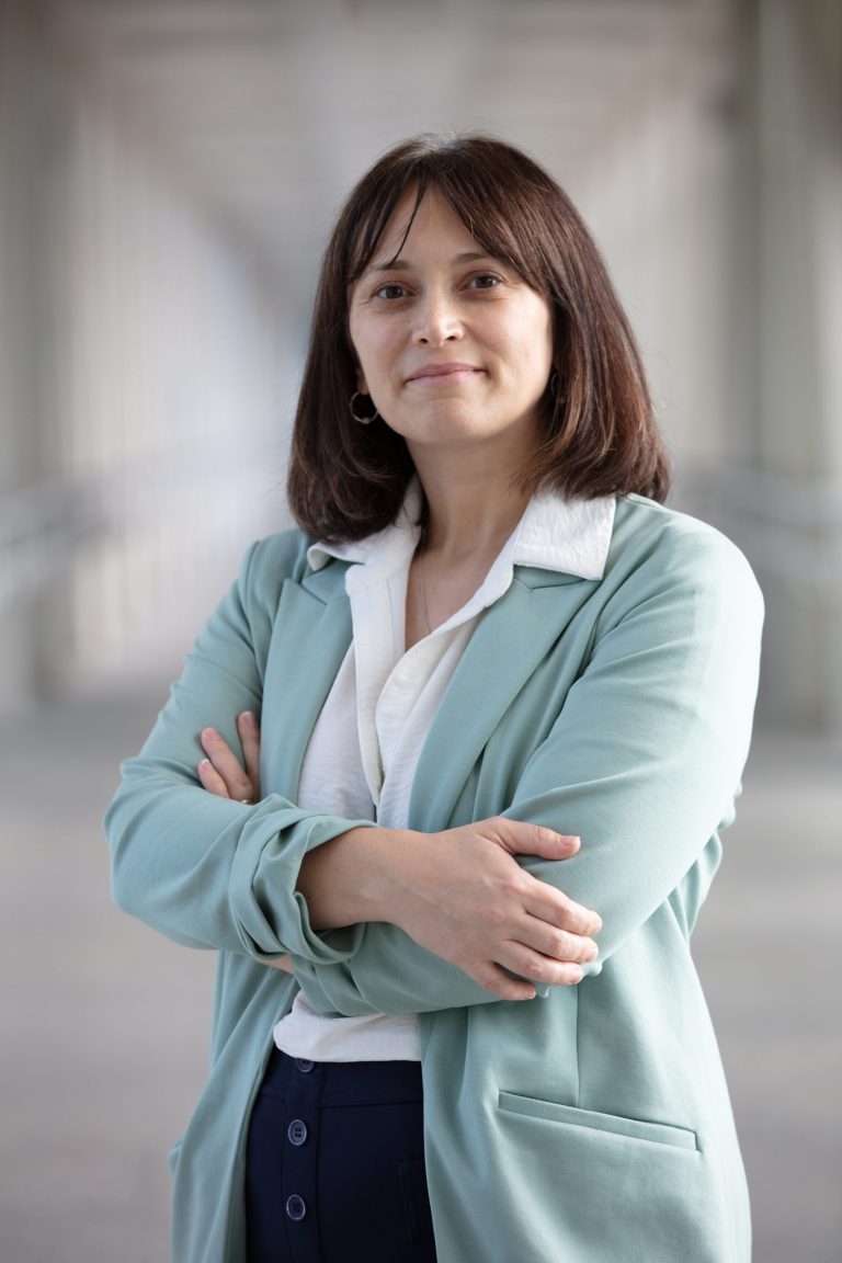 Professional headshot of VPLC employee Victoria Richardson, who has shoulder length brown hair and is wearing a pale green suit jacket with a white button up shirt underneath.